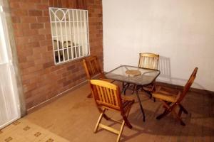 a table with three chairs and a table with a glass top at Casa Anillo vía, cerca a CC Cañaveral y Clínica in Floridablanca