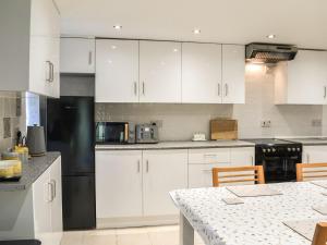 a kitchen with white cabinets and a table with chairs at The Beehive in Miningsby