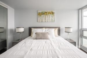 a bedroom with a large white bed with two lamps at GLOBALSTAY 1 Bedroom & Den Condo in the Heart of Downtown Toronto in Toronto