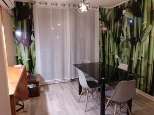 a dining room with a black table and white chairs at Departamento Los Andes in Los Andes