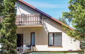 a house with a balcony and a table on the porch at Holiday Home Choczewo Ulwschodnia in Lubiatowo
