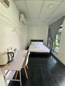 a small room with a bed and a desk and a table at 1108 Carebin Slim River in Slim River