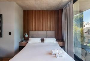 ein Schlafzimmer mit einem großen Bett und einem großen Fenster in der Unterkunft Live Soho Boutique & Apartments Palermo Soho in Buenos Aires
