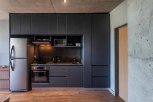 a kitchen with black cabinets and a white refrigerator at Live Soho Boutique & Apartments Palermo Soho in Buenos Aires