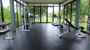 a gym with treadmills and machines in a building at Baan Chan Talay - D32 A modern comfortable 2 bedroom apartment in Chaam in Ban Bang Sai Yoi