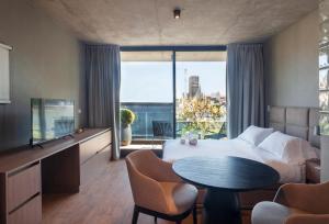 ブエノスアイレスにあるLive Soho Boutique & Apartments Palermo Sohoのベッドと大きな窓が備わるホテルルームです。