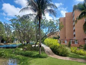 a palm tree in front of a building at Baan Chan Talay - D32 A modern comfortable 2 bedroom apartment in Chaam in Ban Bang Sai Yoi