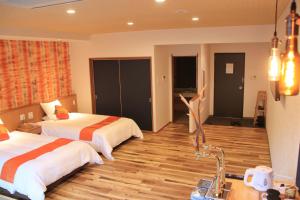 una camera con due letti e pavimenti in legno di Hinotani Onsen Misugi Resort a Tsu