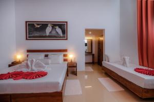 a bedroom with two beds and a room with two tables at Sigiri Asna Nature Resort in Sigiriya