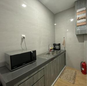 a kitchen with a counter with a microwave and a sink at CN Homestay B3 Floor 2 at Nagoya Hill Mall in Nagoya