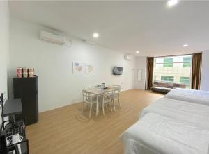 ナゴヤにあるCN Homestay B1 Floor 2 at Nagoya Hill Mallのベッドとテーブルと椅子のある寝室