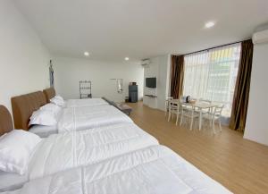 ナゴヤにあるCN Homestay B3 Floor 2 at Nagoya Hill Mallのベッドルーム1室(白い大型ベッド2台、テーブル付)
