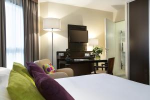 a hotel room with a bed and a desk at Citadines République Paris in Paris