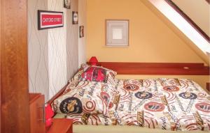 a bed with a comforter on it in a room at Beautiful Apartment In Wladyslawowo With 2 Bedrooms And Wifi in Władysławowo