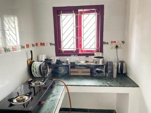une cuisine avec une cuisinière et une fenêtre dans l'établissement WHITE HOUSE - 3BHK Elite Apartment, à Coimbatore