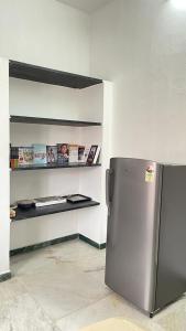 una cucina con frigorifero in acciaio inossidabile in una camera di WHITE HOUSE - 3BHK Elite Apartment a Coimbatore