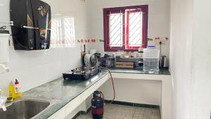 a kitchen with a counter with a sink and a window at WHITE HOUSE - 3BHK Elite Apartment in Coimbatore