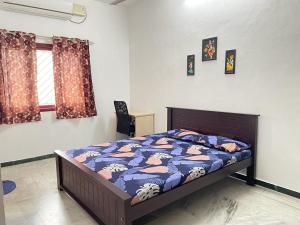 a bedroom with a bed with a blue comforter at WHITE HOUSE - 3BHK Elite Apartment in Coimbatore