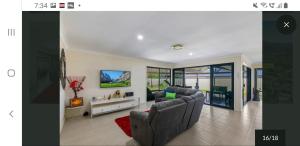 a living room with two couches and a tv at Jen's Getaway in Glass House Mountains