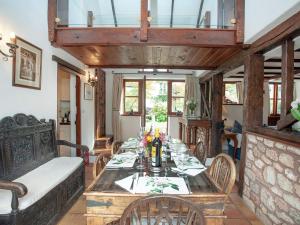 a dining room with a table and a couch at The Barn in Kentisbeare