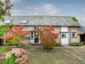 a brick house with a white garage at The Barn in Kentisbeare