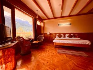 a bedroom with a bed and a large window at Valley of Gods, Vashisht Manali in Manāli