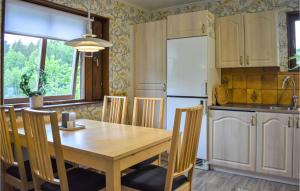 a kitchen with a wooden table and a white refrigerator at Awesome Home In Asarum With Wifi in Asarum