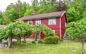 Asarum的住宿－Awesome Home In Asarum With Wifi，一座有树木的院子中的红色房子