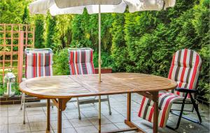 a wooden table with chairs and an umbrella on a patio at Holiday Home Kaminsko Uljalowcowa in Kamińsko +6 photos