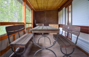 een houten tafel en 2 stoelen op een veranda bij 2 Bedroom Lovely Home In Legbad in Legbąd