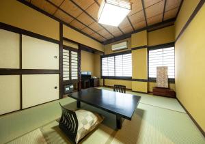 una habitación con una mesa y un sofá. en Ryokan Kiraku en Beppu