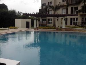 a large blue swimming pool in front of a building at Monteluce Condominium Apartment in Silang