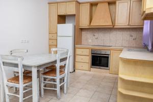 a kitchen with a table and chairs and a refrigerator at Depis economy apartments in Naxos Chora