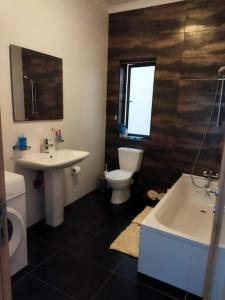 een badkamer met een toilet, een wastafel en een bad bij Seafront apartment at Waters' Edge in St Paul's Bay