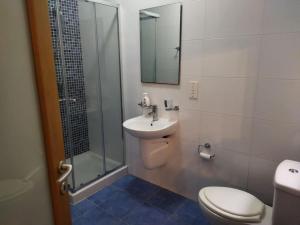 een badkamer met een toilet, een wastafel en een douche bij Seafront apartment at Waters' Edge in St Paul's Bay