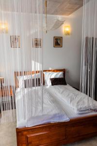 sypialnia z łóżkiem z baldachimem i białymi zasłonami w obiekcie Pensiunea Luna w mieście Buşteni