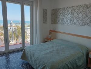 1 dormitorio con cama y vistas al océano en Hotel Rosa Meublé, en Porto San Giorgio