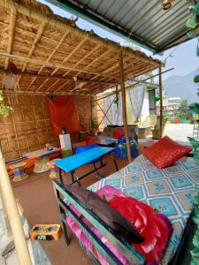 a room with a bed and a table and a tent at Hobbit House Hostel in Rishīkesh
