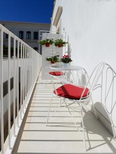 un tavolo e 2 sedie sul balcone di Dimora del Cuore struttura self check in a Vieste