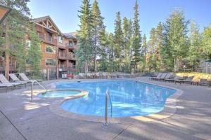 Una gran piscina con sillas y un edificio. en Luxury 1 Bedroom Mountain Vacation Rental In Breckenridge With Access To A Hot Tub And Heated Garage Parking, en Breckenridge