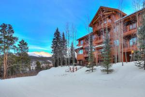 Un gran edificio de madera en la nieve frente a él. en Luxury 1 Bedroom Mountain Vacation Rental In Breckenridge With Access To A Hot Tub And Heated Garage Parking, en Breckenridge