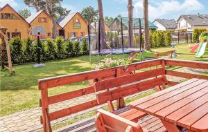 a wooden bench with a playground in a park at Nice Home In Jaroslawiec With 2 Bedrooms And Wifi in Jarosławiec