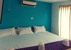 a bedroom with a blue wall and a large bed at Hotel Ceylon Heritage in Yala