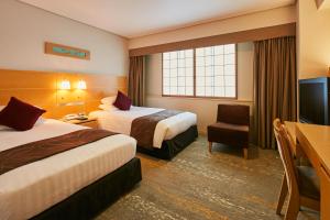 a hotel room with two beds and a television at Akasaka Excel Hotel Tokyu in Tokyo