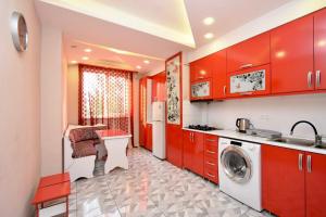 a kitchen with red cabinets and a washing machine at Three Rooms Center Yerevan 6 in Yerevan