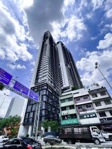 een hoog gebouw met straatborden ervoor bij Continew Residences TRX Lux Pool View in Kuala Lumpur