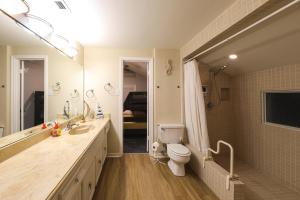 a bathroom with a toilet and a sink and a mirror at Beach Mode ON! in Galveston +25 photos
