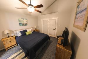 sypialnia z łóżkiem i wentylatorem sufitowym w obiekcie Beach Mode ON! w mieście Galveston