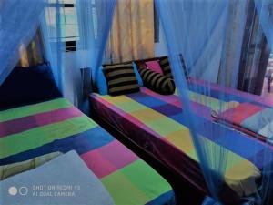 1 dormitorio con 1 cama colorida y ventana en Ella Tunnel Corner Inn, en Ella