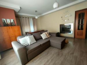 a living room with a couch and a clock on the wall at Alto Minho Central Apartment in Paredes de Coura